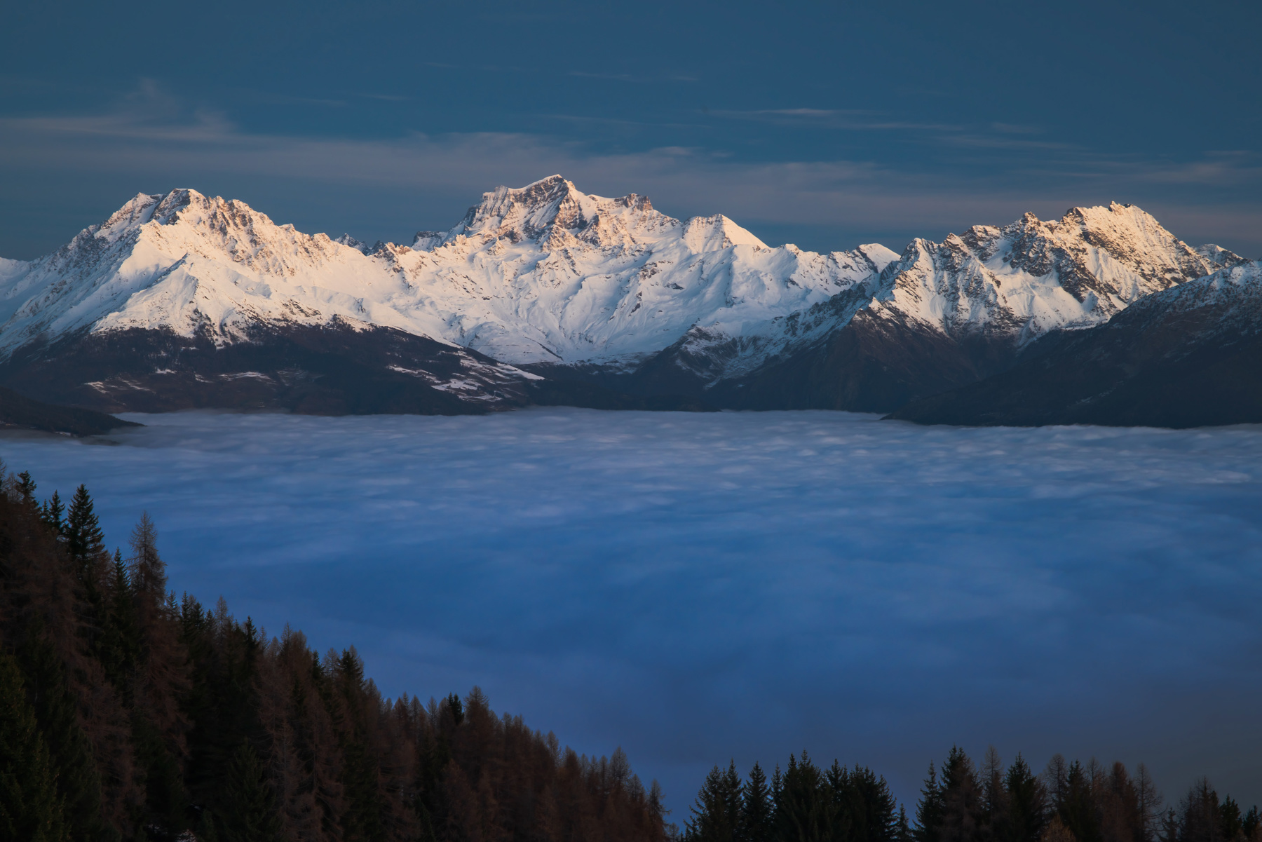 a lake surrounded by snow covered mountains. nature outdoor landscape sky mountain range cloud glacial landform alps summit massif ridge moraine glacier tree snow mountain glacial lake lake wilderness winter