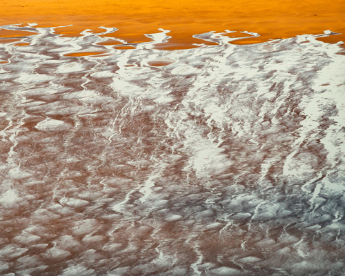 Reflections:  a cracked surface with orange and white stripes