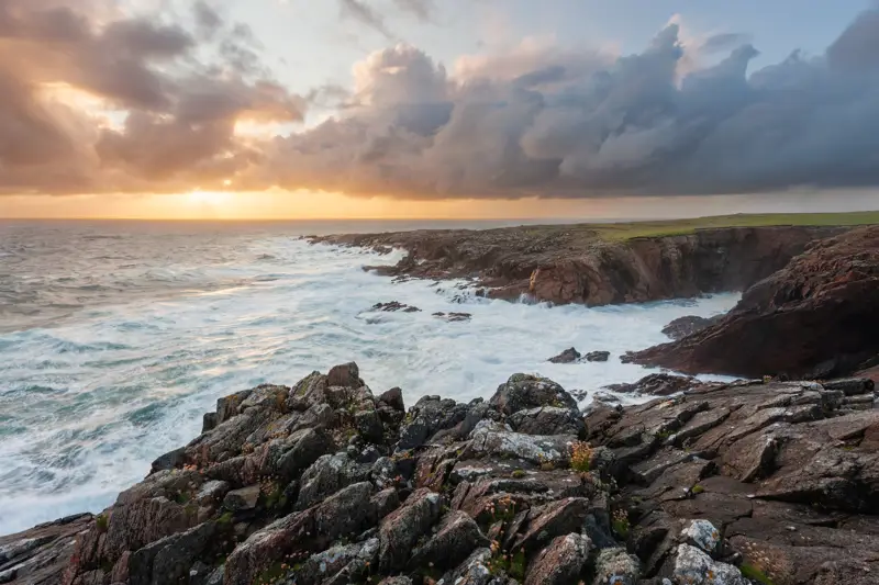 a rocky beach with a body of water in the background. cloud outdoor nature sky water landscape rock sunrise coastal and oceanic landforms tide seascape horizon coast wind wave body of water wave sea ocean beach headland tide pool cape cloudy shore sunset