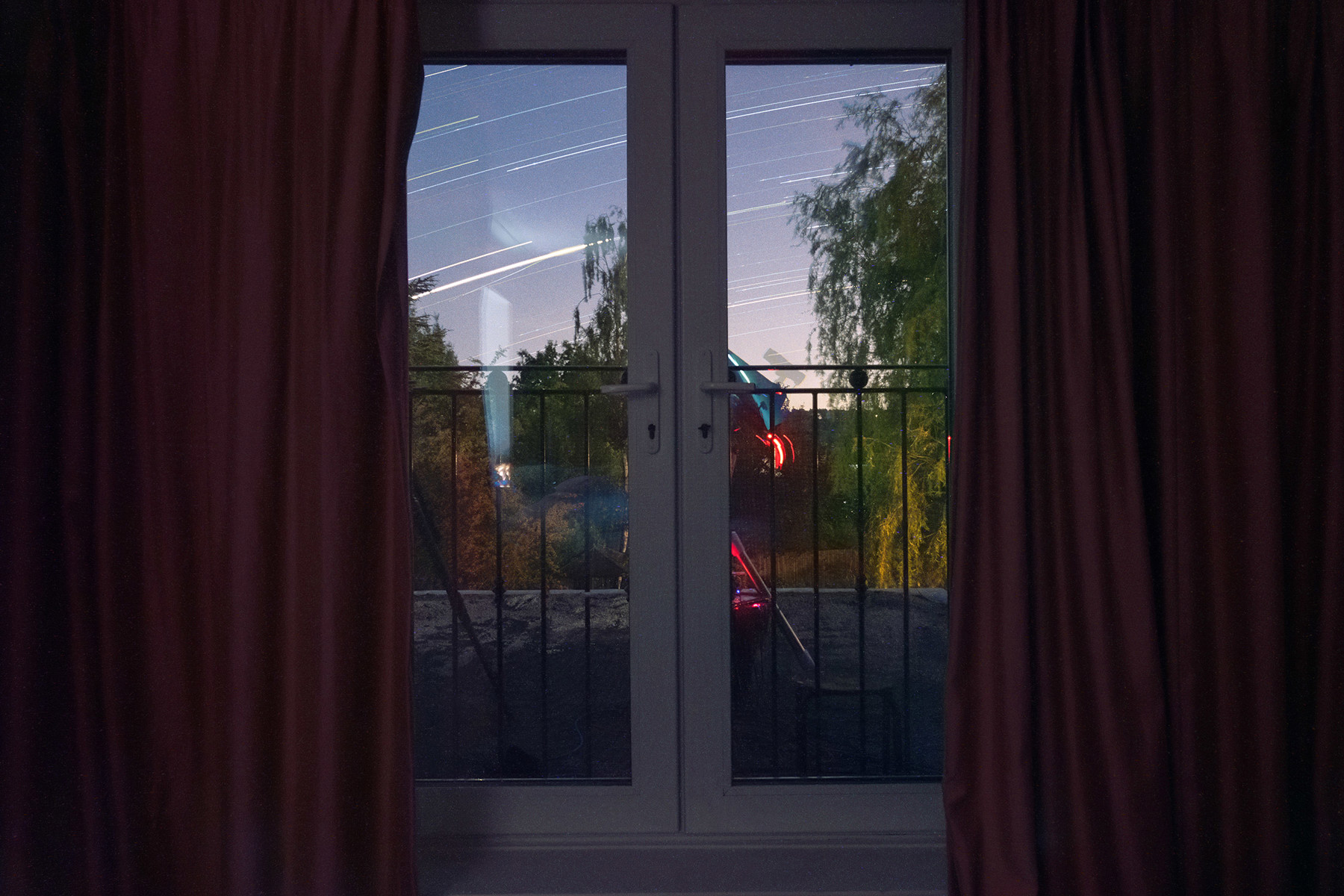 a red curtain and a window. curtain indoor red furniture door tree house window sky