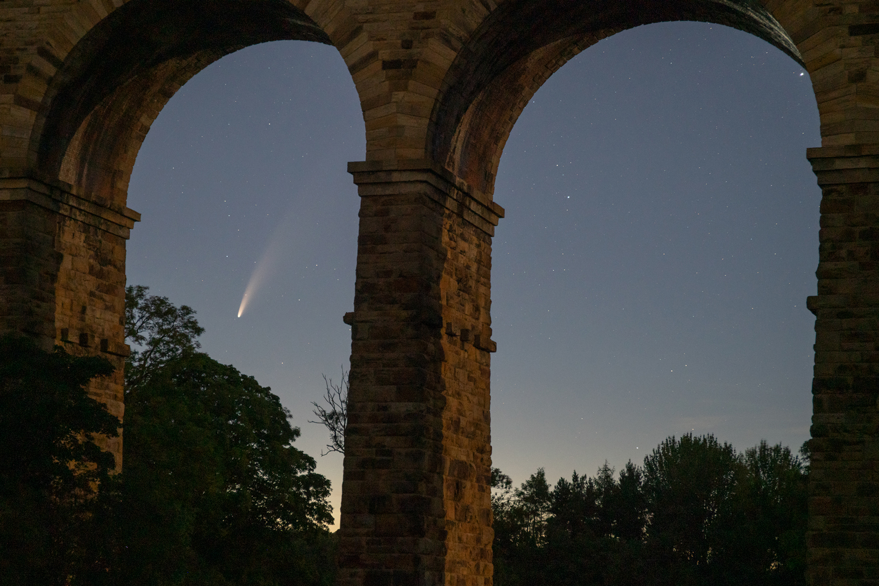 a large stone building. tree outdoor building sky arch cloud