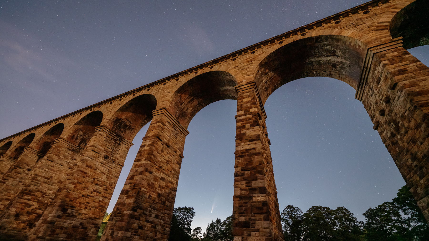 a close up of a bridge. sky outdoor building bridge aqueduct arch viaduct tree